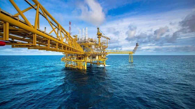 Yellow offshore oil rig platform surrounded by blue ocean