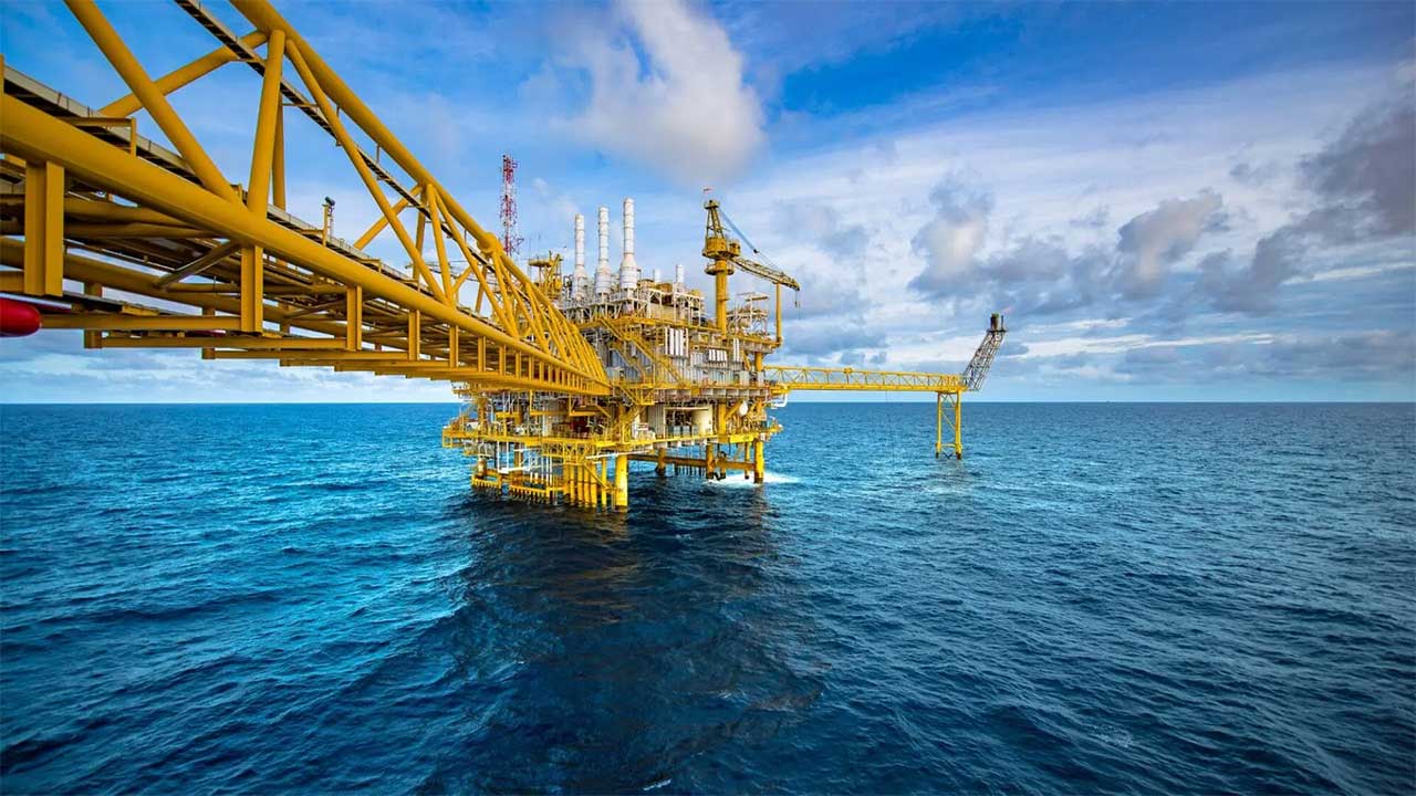 Yellow offshore oil rig platform surrounded by blue ocean