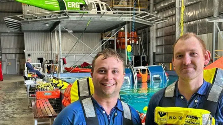 Ed Rowley in a safety vest smiling within a training facility next to pool