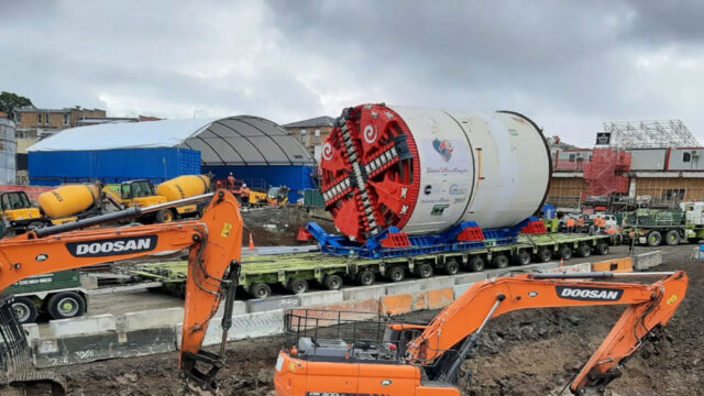 Construction site with large tunnel boring machine and two orange excavators