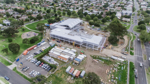 Aerial view of a large building under construction in suburban an area near a residential neighborhood
