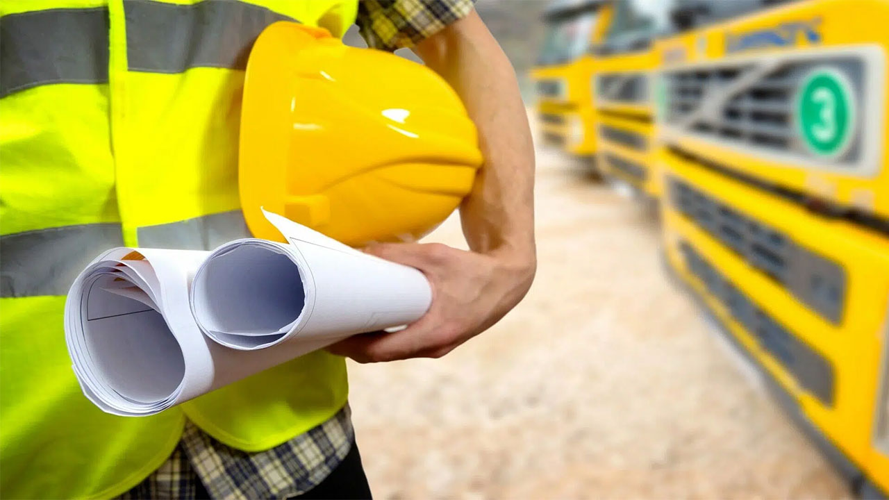 A closeup of a worker holding a construction hat with plans rolled up in hand