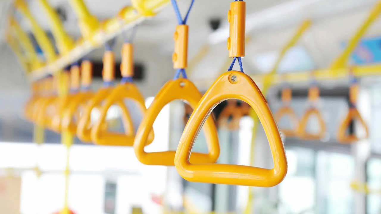 Close-up of yellow hand straps suspended from the ceiling of a public transportation vehicle