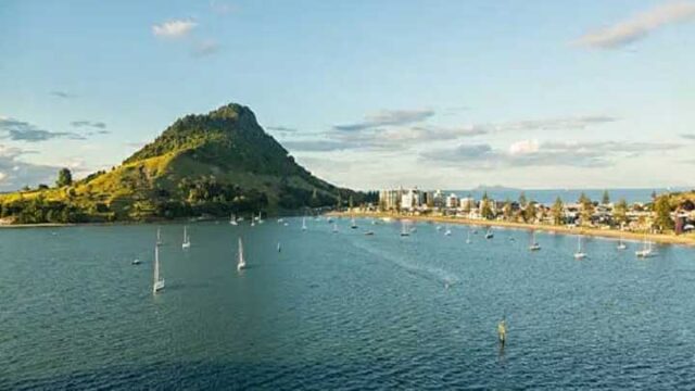 Scenic view of Tauranga, New Zealand, featuring sailboats in the harbor and Mount Maunganui in the background